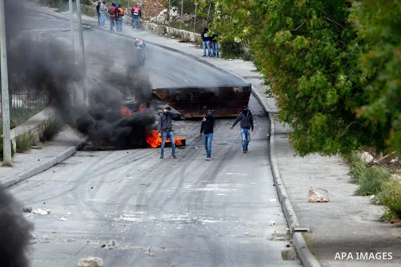 A Palestinian demonstrator carries rocks during clashes with Israeli border guards in the Issawiya district of Arab east Jerusalem on April 5, 2013. Israeli police dispersed Palestinian demonstrators after Muslim prayers...