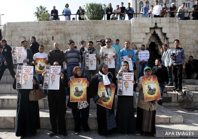 Palestinians hold pictures of prisoner Samer al-Issawi held in Israeli jails during a protest in Jerusalem, in solidarity with hunger-striking detainees held by Israel to demand their release from detention without trial...