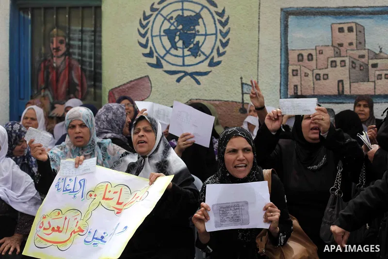Palestinian women hold up their refugee ration cards during a protest demanding the United Nations Relief and Works Agency (UNRWA) to resume aid for refugees in Gaza City April 8, 2013. The main U.N. humanitarian agency...