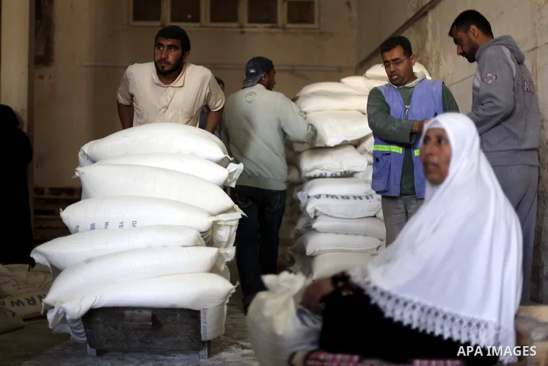 A Palestinian refugee rests next to a flour sack received from United Nations Relief and Works Agency (UNRWA) inside a United Nations food distribution centre in Gaza City April 10, 2013. The main U.N. humanitarian agenc...