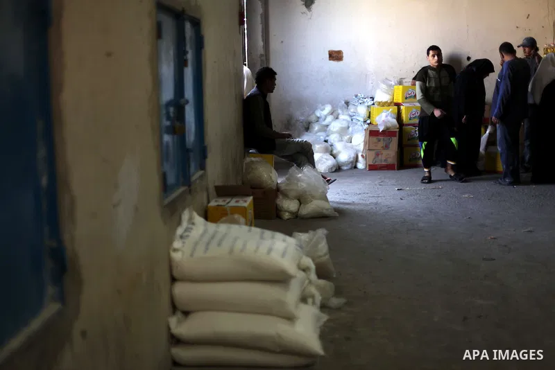 Palestinians receive food supplies inside a United Nations food distribution centre in Gaza City April 10, 2013. The main U.N. humanitarian agency for Palestinians said on Monday it was reopening its Gaza food distributi...
