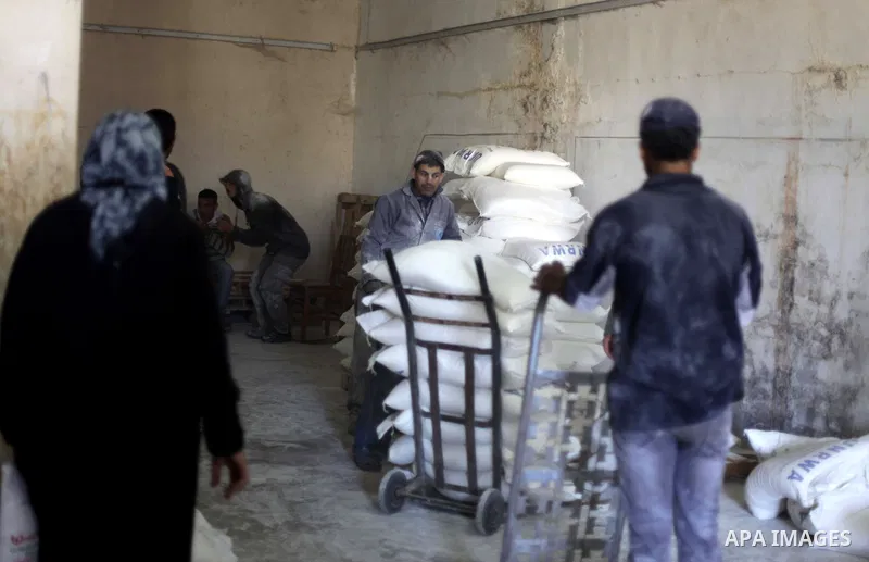 Palestinians receive food supplies inside a United Nations food distribution centre in Gaza City April 10, 2013. The main U.N. humanitarian agency for Palestinians said on Monday it was reopening its Gaza food distributi...