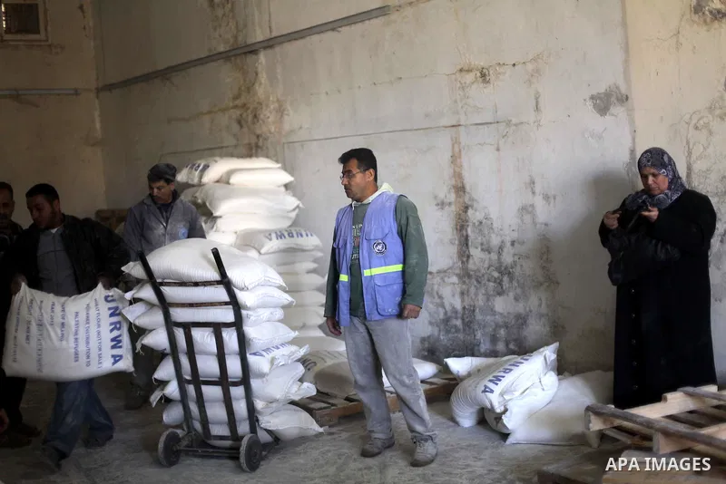 Palestinians receive food supplies inside a United Nations food distribution centre in Gaza City April 10, 2013. The main U.N. humanitarian agency for Palestinians said on Monday it was reopening its Gaza food distributi...