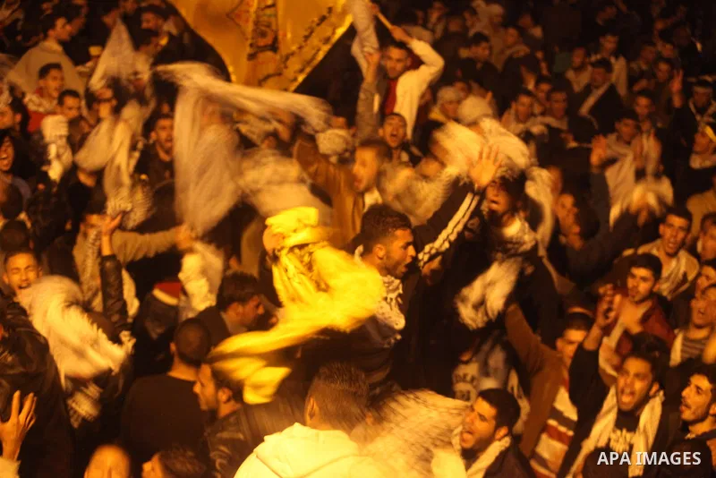 Birtzeit University students loyal to Fatah celebrate their victory over Hamas in the university elections, next to the Birzeit University campus near the West Bank city of Ramallah, on April 10, 2013. Fatah won 23 seats...