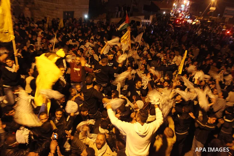 Birtzeit University students loyal to Fatah celebrate their victory over Hamas in the university elections, next to the Birzeit University campus near the West Bank city of Ramallah, on April 10, 2013. Fatah won 23 seats...