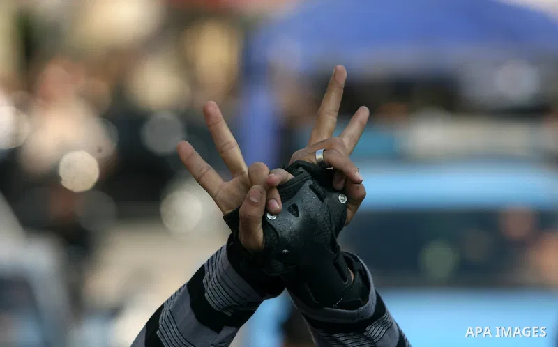 A member of Palestinian youth skate team flashes victory sign as he takes part in a rally to show solidarity with Palestinian prisoners inside Israeli jails, ahead of Palestinian prisoner's day in south of Gaza strip tow...