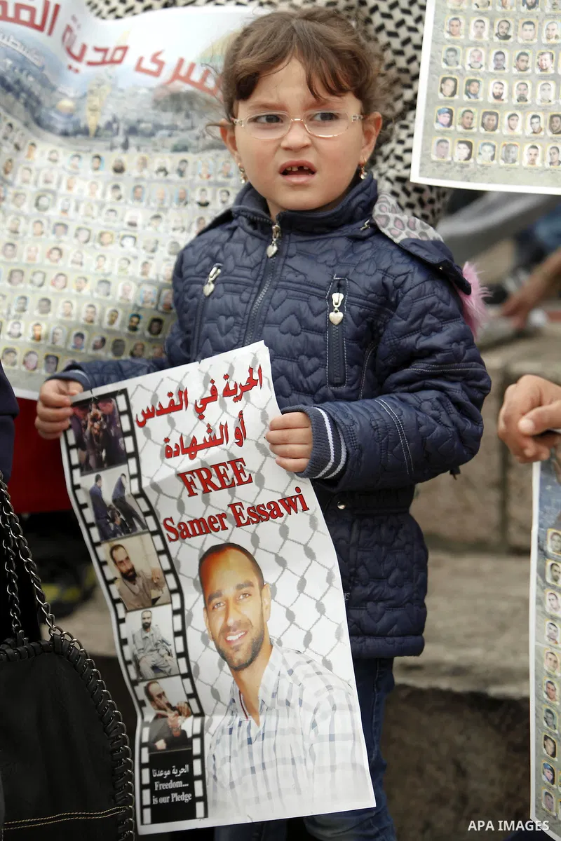 Palestinians hold portraits of relatives jailed in Israeli prisons as they protest to demand for their release during a demonstration to mark the Prisoners' Day outside Damascus gate, in the old city of Jerusalem on Apri...