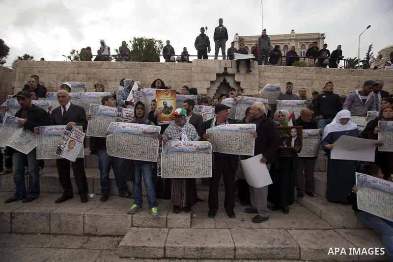 Palestinians hold portraits of relatives jailed in Israeli prisons as they protest to demand for their release during a demonstration to mark the Prisoners' Day outside Damascus gate, in the old city of Jerusalem on Apri...