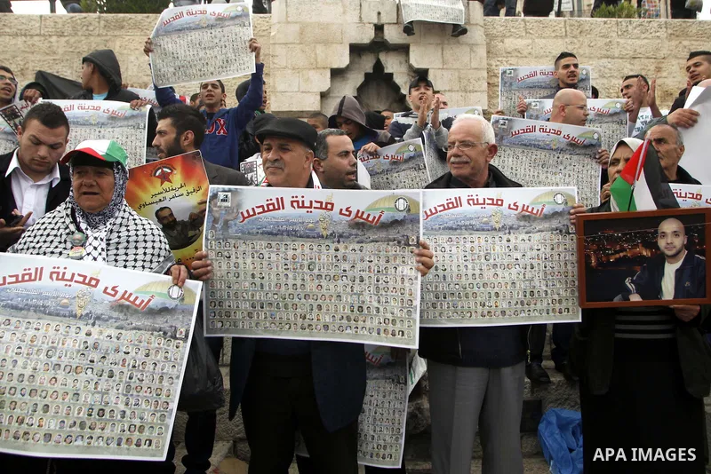 Palestinians hold portraits of relatives jailed in Israeli prisons as they protest to demand for their release during a demonstration to mark the Prisoners' Day outside Damascus gate, in the old city of Jerusalem on Apri...