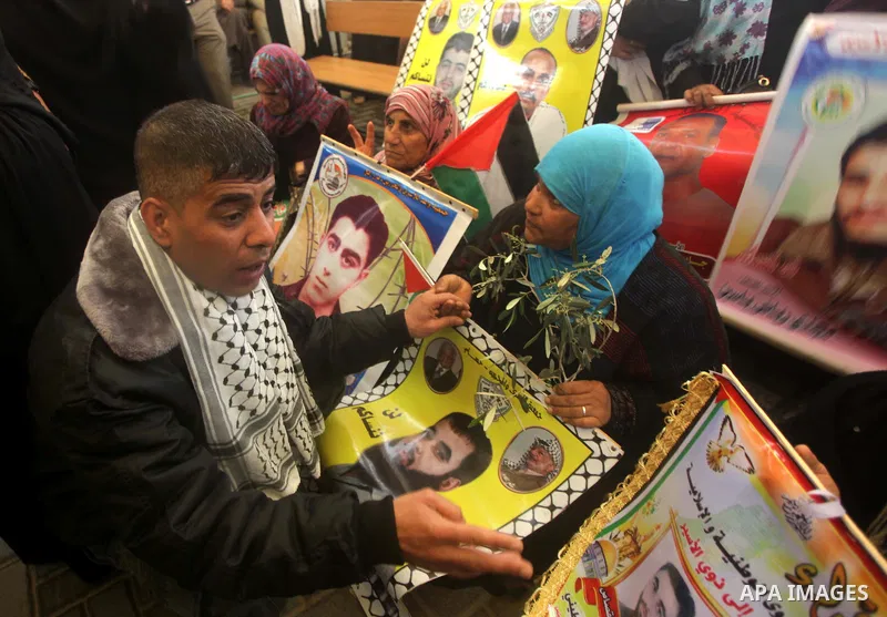Palestinian women hold pictures of prisoners held in Israeli jails during a protest in front of the Red Cross offices in Gaza city, on Apr. 22, 2013 in solidarity with Palestinian prisoners held by Israel to demand their...