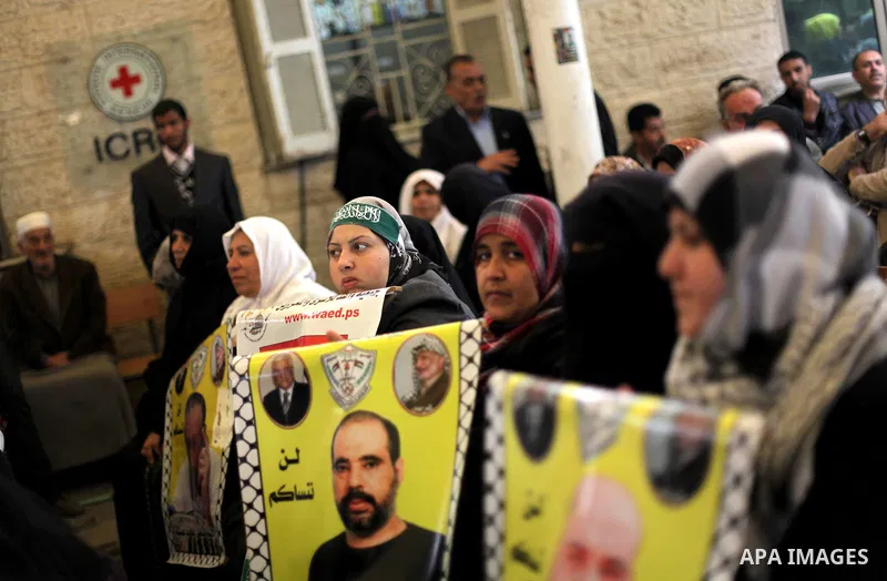 Palestinian women hold pictures of prisoners held in Israeli jails during a protest in front of the Red Cross offices in Gaza city, on Apr. 22, 2013 in solidarity with Palestinian prisoners held by Israel to demand their...