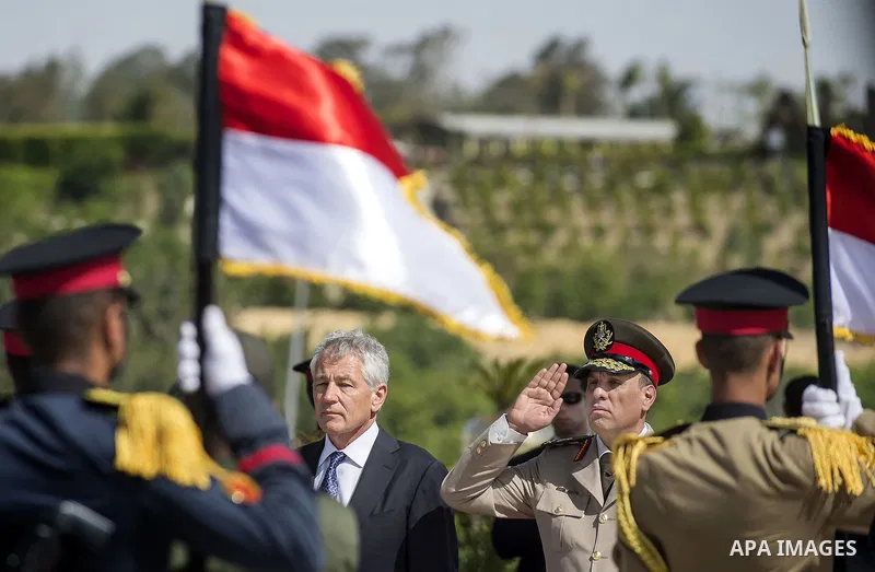 Egypt's President Mohamed Mursi (C) walks after laying a wreath during his visit to the tomb of former President Anwar al-Sadat and the Tomb of the Unknown Soldier during the commemoration of Sinai Liberation Day in Cair...
