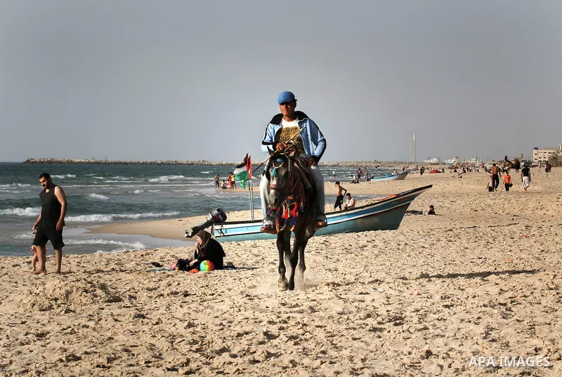 Palestinians enjoy a day at the beach of Gaza city during hot weather on April 28, 2013. Photo by Sameh Rahmi
