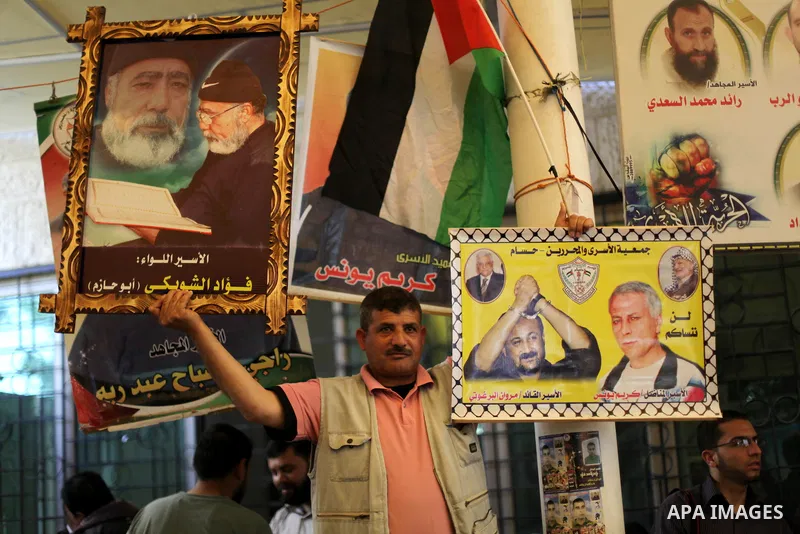 Palestinians hold pictures of prisoners held in Israeli jails during a protest in front of the Red Cross offices in Gaza city, on Apr. 29, 2013 in solidarity with Palestinian prisoners held by Israel to demand their rele...