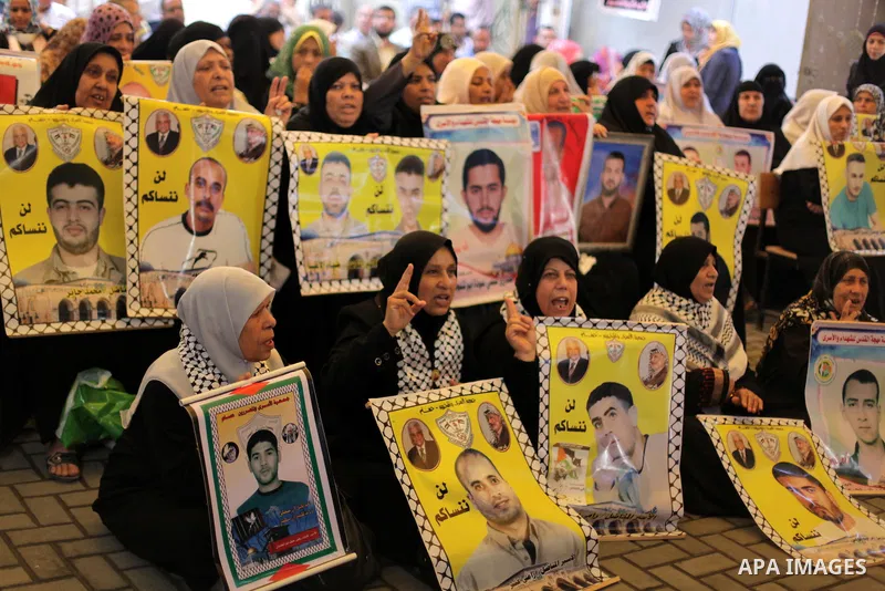 Palestinian women hold pictures of prisoners held in Israeli jails during a protest in front of the Red Cross offices in Gaza city, on Apr. 29, 2013 in solidarity with Palestinian prisoners held by Israel to demand their...