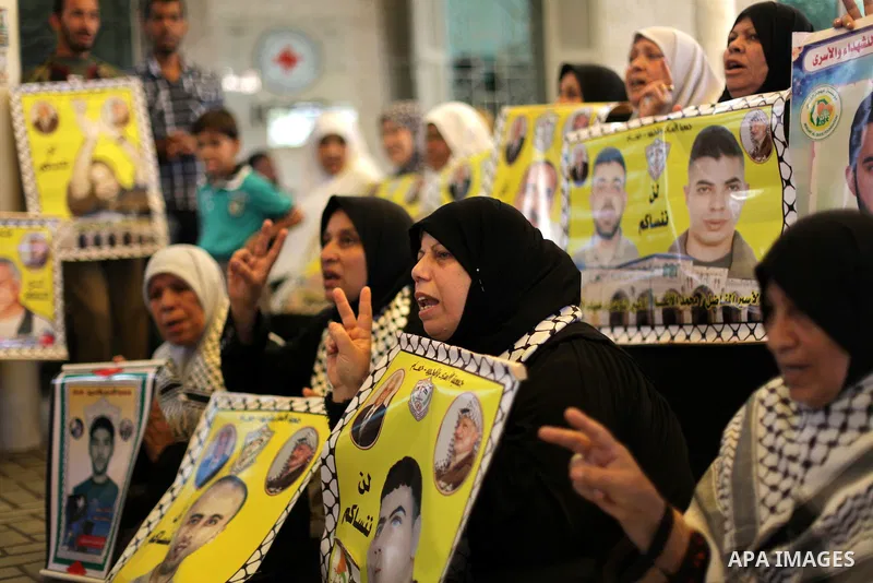 Palestinian women hold pictures of prisoners held in Israeli jails during a protest in front of the Red Cross offices in Gaza city, on Apr. 29, 2013 in solidarity with Palestinian prisoners held by Israel to demand their...