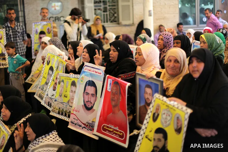 Palestinian women hold pictures of prisoners held in Israeli jails during a protest in front of the Red Cross offices in Gaza city, on Apr. 29, 2013 in solidarity with Palestinian prisoners held by Israel to demand their...