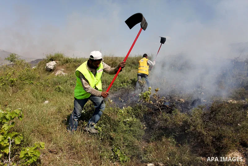 Palestinian firefighters try to extinguish a fire in the West Bank town of Aseera al-Qabliya, near Nablus, Tuesday, April 30, 2013. In the West Bank, a Palestinian man fatally stabbed an Israeli waiting at a bus stop and...