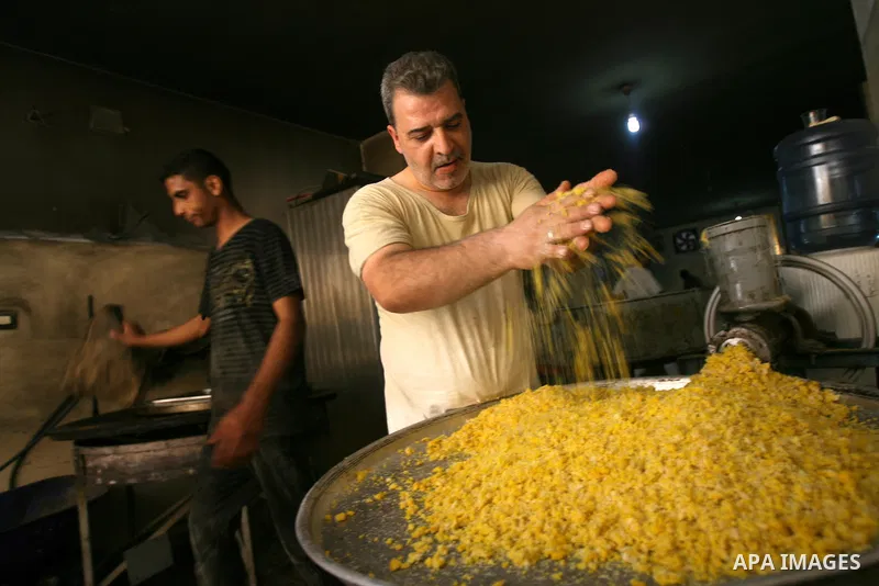 Syrian refugee Jehad El-Shami, 41, makes sweets at a shop in Khan Youns in southern Gaza Strip, on May 5, 2013. El-Shami arrived to Gaza strip since 6 months following his release from Syrian army jails in Damascus, he i...