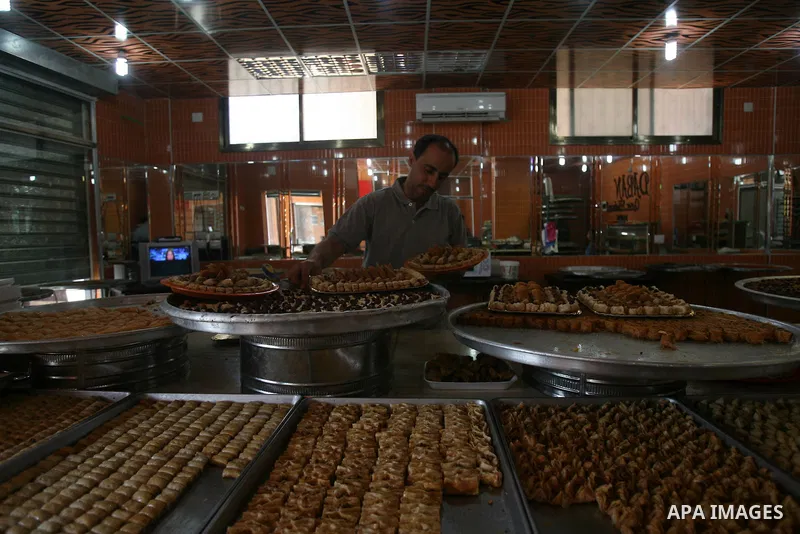 Syrian refugee Jehad El-Shami, 41, makes sweets at a shop in Khan Youns in southern Gaza Strip, on May 5, 2013. El-Shami arrived to Gaza strip since 6 months following his release from Syrian army jails in Damascus, he i...
