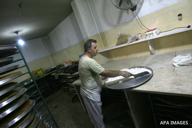 Syrian refugee Jehad El-Shami, 41, makes sweets at a shop in Khan Youns in southern Gaza Strip, on May 5, 2013. El-Shami arrived to Gaza strip since 6 months following his release from Syrian army jails in Damascus, he i...