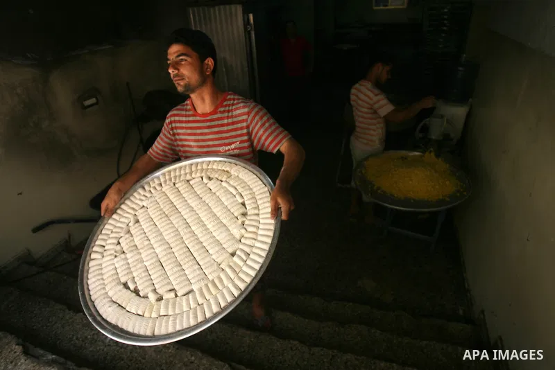 Syrian refugee Jehad El-Shami, 41, makes sweets at a shop in Khan Youns in southern Gaza Strip, on May 5, 2013. El-Shami arrived to Gaza strip since 6 months following his release from Syrian army jails in Damascus, he i...