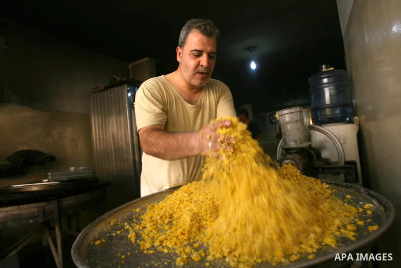 Syrian refugee Jehad El-Shami, 41, makes sweets at a shop in Khan Youns in southern Gaza Strip, on May 5, 2013. El-Shami arrived to Gaza strip since 6 months following his release from Syrian army jails in Damascus, he i...