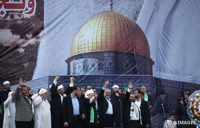 Palestinian Prime Minister in Gaza Strip Ismail Haniyeh and Egyptian Cleric and chairman of the International Union of Muslim Scholars Sheikh Yusuf al-Qaradawi, wave to the crowd during a welcoming ceremony in Gaza city...
