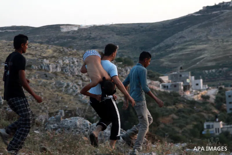 Palestinians and Israeli settlers hurl stones at each other during clashes in the northern West Bank village of Burin on May 11, 2013 after the settlers marched into the village, witnesses said. Photo by Nedal Eshtayah