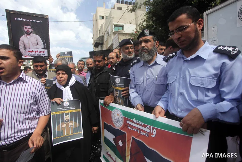 Palestinians hold pictures of prisoners held in Israeli jails during a protest in front of the Red Cross offices in Gaza city, on May. 13, 2013 in solidarity with Palestinian prisoners held by Israel to demand their rele...