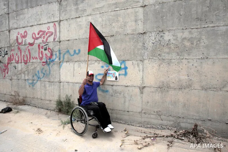 A Palestinian demonstrator takes part in a march next to the Israel's separation barrier ahead of Nakba in the West Bank city of Tulkarem on May 13, 2013. Palestinians and Arab Israelis are preparing to mark Nakba Day on...