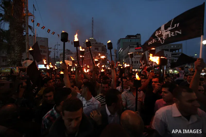 Palestinian protestors hold up torches during a rally to mark the beginning of the Nakba or the ''Day of Catastrophe'', in the old city of Ramallah on May 14, 2013. Palestinians will mark the 65th Nakba as a day of mourn...