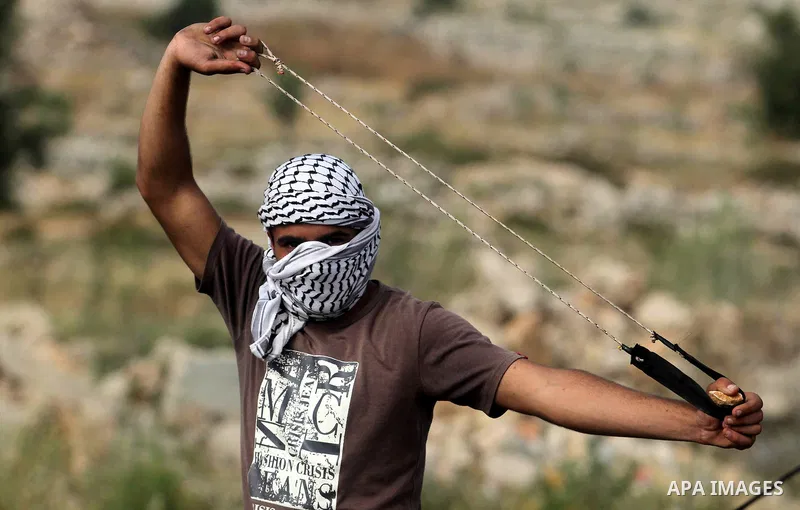 Palestinian youths clash with Israeli soldiers in front of a makeshift roadblock leading to the village of Deir Jarir east of Ramallah on May 18, 2013. Israeli soldiers closed the road leading to Deir Jarir due to ongoin...