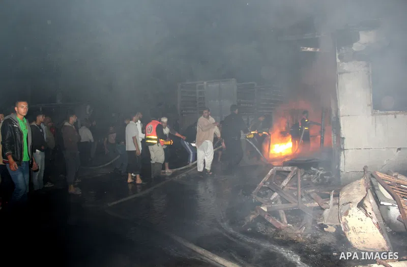 Palestinian firemen try to extinguish a fire at a livestock farm in Rafah in southern Gaza Strip on May 18, 2013. The fire sparked by electrical short circuit next to fuel barrels. Photo by Masad al-Mahmom