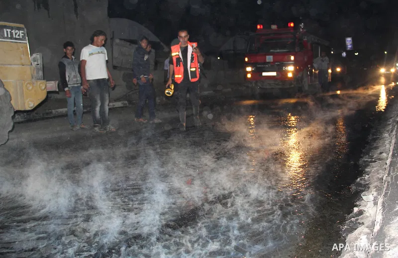 Palestinian firemen try to extinguish a fire at a livestock farm in Rafah in southern Gaza Strip on May 18, 2013. The fire sparked by electrical short circuit next to fuel barrels. Photo by Masad al-Mahmom