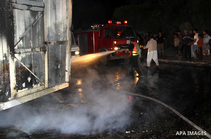Palestinian firemen try to extinguish a fire at a livestock farm in Rafah in southern Gaza Strip on May 18, 2013. The fire sparked by electrical short circuit next to fuel barrels. Photo by Masad al-Mahmom