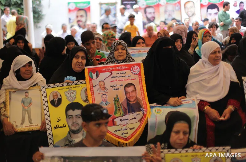 Palestinian woman hold pictures of prisoners held in Israeli jails during a protest at inside Red Cross office in Gaza City, on May. 20, 2013 in solidarity with Palestinian prisoners held by Israel to demand their releas...