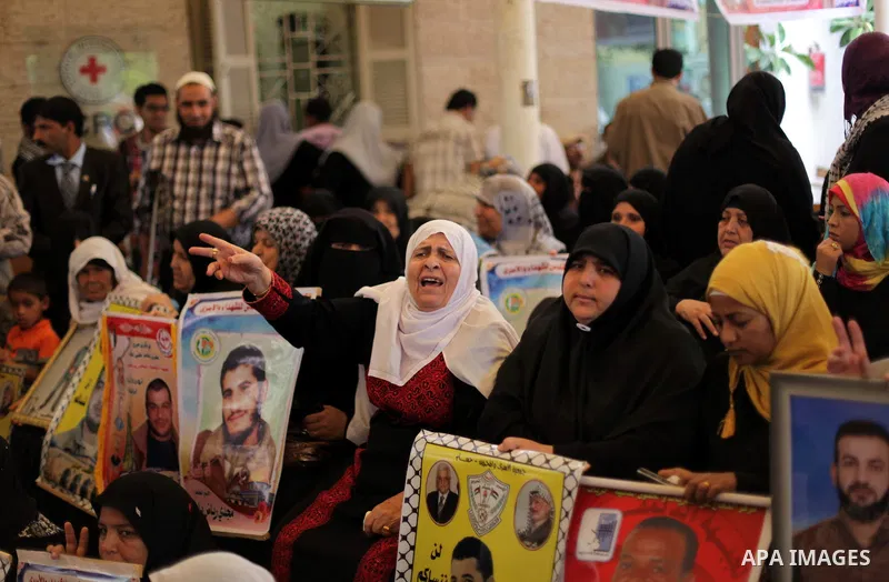 Palestinian woman hold pictures of prisoners held in Israeli jails during a protest at inside Red Cross office in Gaza City, on May. 20, 2013 in solidarity with Palestinian prisoners held by Israel to demand their releas...