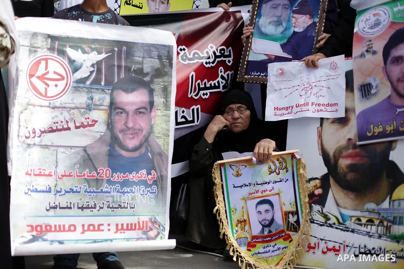 Palestinian woman hold pictures of prisoners held in Israeli jails during a protest at inside Red Cross office in Gaza City, on May. 20, 2013 in solidarity with Palestinian prisoners held by Israel to demand their releas...
