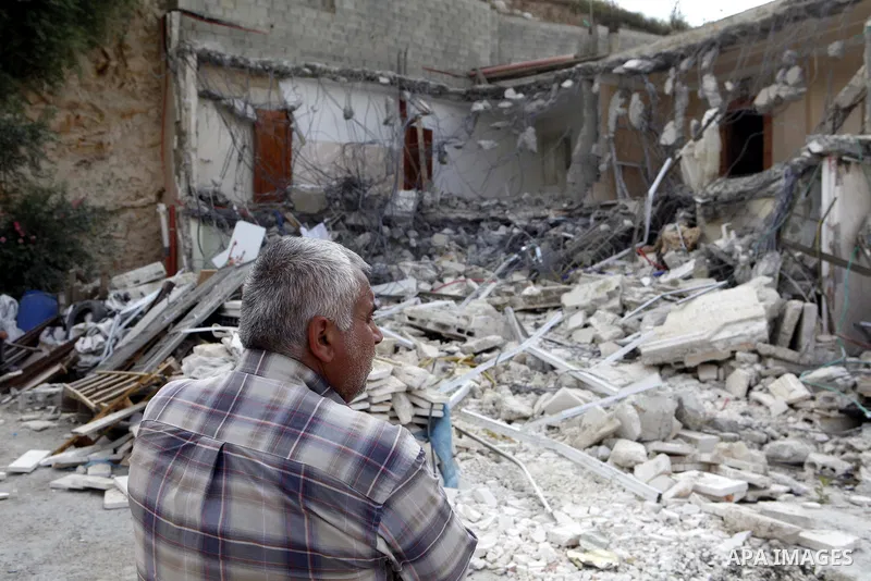 A Palestinian man stands on the rubble of his house after it was demolished by Israeli bulldozers in the neighborhood of al-Tur in Israeli-occupied east Jerusalem on May 21, 2013, in implementation of a court order which...