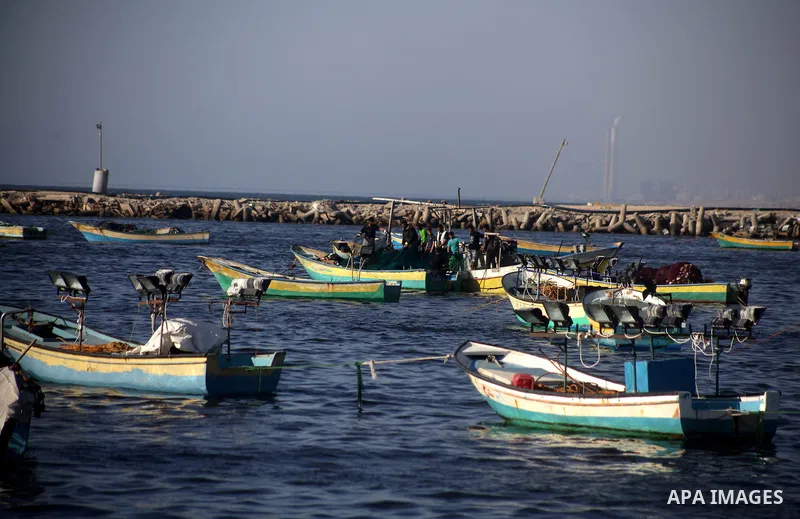 Palestinian fishermen work on their boats at the port in Gaza City, Tuesday, May 21, 2013. Israel on Tuesday expanded the distance it permits Gaza fishermen to head out to sea from 3 miles to 6 miles, restoring a limit i...