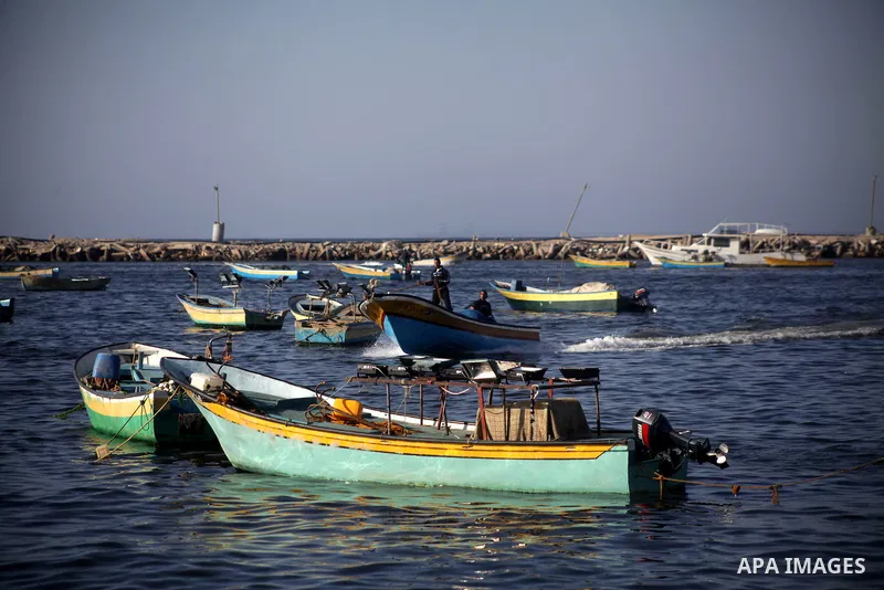 Palestinian fishermen work on their boats at the port in Gaza City, Tuesday, May 21, 2013. Israel on Tuesday expanded the distance it permits Gaza fishermen to head out to sea from 3 miles to 6 miles, restoring a limit i...