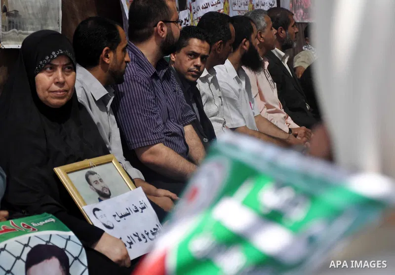 Palestinians hold pictures of prisoners held in Israeli jails during a protest in Gaza City, on May. 23, 2013 in solidarity with Palestinian prisoners on hunger strike in Israeli jails. Photo by Mohammed Talatene