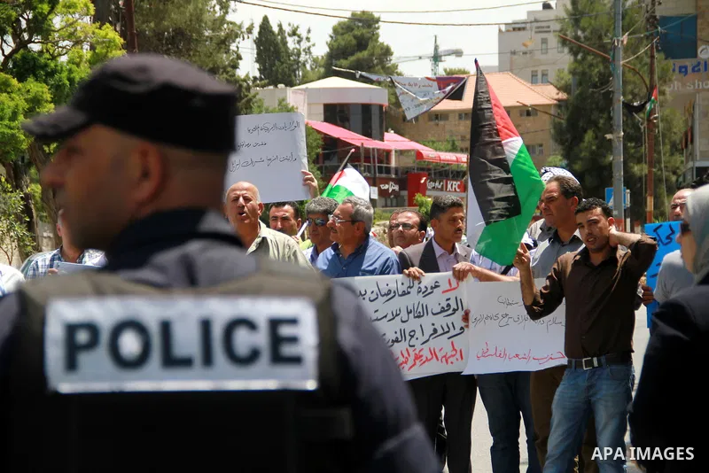 Palestinian men protest against US Secretary of State John Kerry's visit to the West bank town of Ramallah next to the Palestinian President Mahmoud Abbas' headquarter in the West Bank town of Ramallah, 23 May 2013. John...