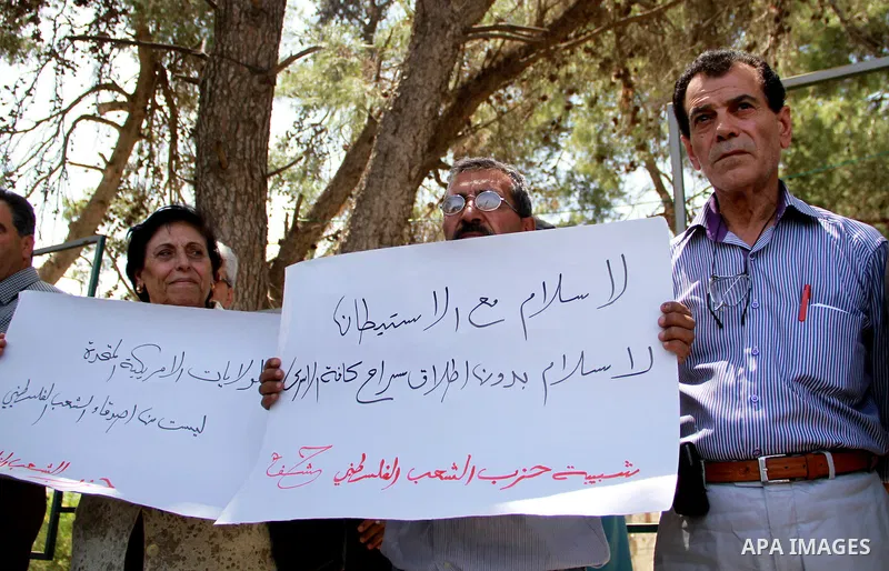 Palestinian men protest against US Secretary of State John Kerry's visit to the West bank town of Ramallah next to the Palestinian President Mahmoud Abbas' headquarter in the West Bank town of Ramallah, 23 May 2013. John...