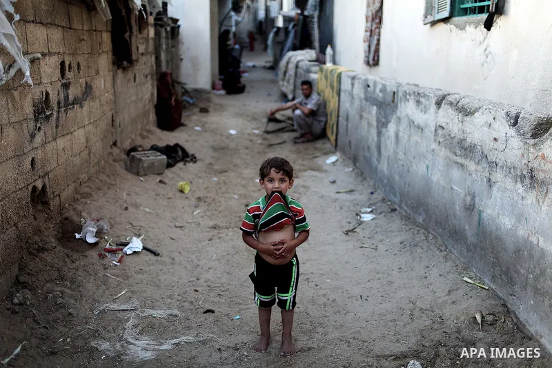 A Palestinian refugee boy stands outside her family house in a poverty-stricken quarter of the town of Beit Lahiya, northern Gaza Strip, 23 May 2013. Photo by Ali Jadallah