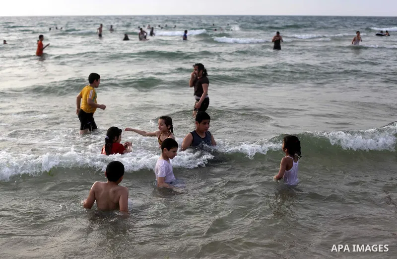 Palestinians enjoy swimming in the sea at Gaza beach during Friday holiday in Gaza city, May 24, 2013. Gazans escape to the beach and out from their homes during heat wave and power outages. Photo by Ashraf Amra