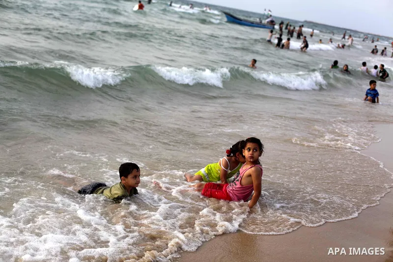 Palestinians enjoy swimming in the sea at Gaza beach during Friday holiday in Gaza city, May 24, 2013. Gazans escape to the beach and out from their homes during heat wave and power outages. Photo by Ashraf Amra