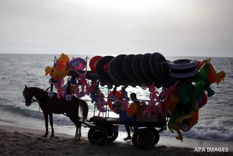 A Palestinian vendor on a beach in Gaza beach during Friday holiday in Gaza city, May 24, 2013. Gazans escape to the beach and out from their homes during heat wave and power outages. Photo by Ashraf Amra
