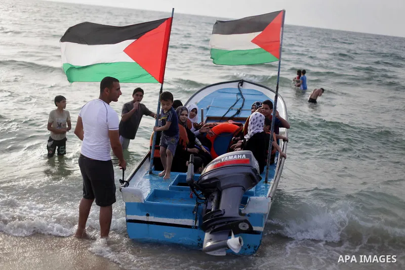 Palestinians enjoy riding a boat on the sea at Gaza beach during Friday holiday in Gaza city, May 24, 2013. Gazans escape to the beach and out from their homes during heat wave and power outages. Photo by Ashraf Amra